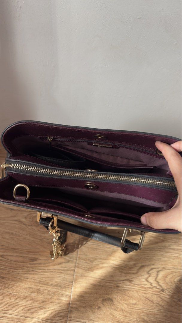 Aldo Black and Maroon Structured Tote Handbag (Category: Tote Bags) located in Lipa City. Submitted by eden.cheexe (Listing ID 1468283036, Image 3). Description: - Brand: Aldo - Color: Classic black exterior with a stylish maroon interior - Hardware: Gold-tone accents and front logo branding - Extras: Removable gold padlock and chain charm included - Compartments: Center zipped compartment with open sections and magnetic closure - Organization: M
