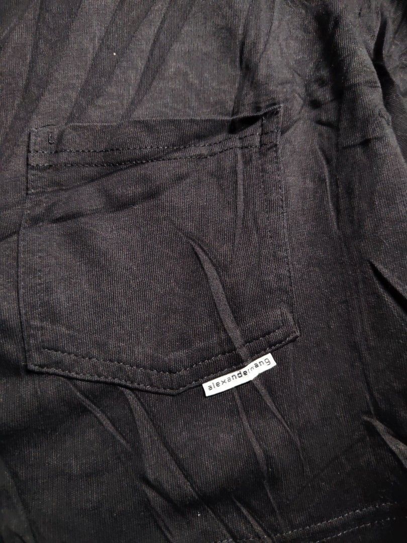 Alexander Wang Black Crop Top with Pocket (Category: Shirts) located in Baguio. Submitted by angeloshoppebaguio2600 (Listing ID 1468137612, Image 2). Description: Alexander Wang black cropped t-shirt. Chest pocket with small logo tag. Scoop neck, short sleeves. Made in China, 100% polyester body. Measurements: length 14.1 inches, underarm width 19.4 inches. Casual streetwear piece, easy to style with high-waisted bottoms..