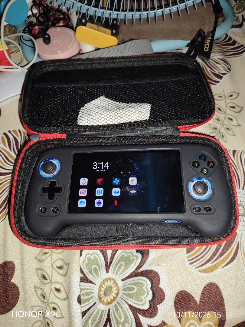Anbernic RG556 (Category: Nintendo) located in Manila. Submitted by flashghie (Listing ID 1468164823, Image 1). Description: - Anbernic Android handheld gaming console in working condition - Custom UI setup with convenient home screen app shortcuts - Dual analog sticks, D-pad, and standard ABXY buttons - Includes fitted black protective silicone grip case - Comes with a zippered hard shell carry case featuring red trim and inner mesh pocket - Pow