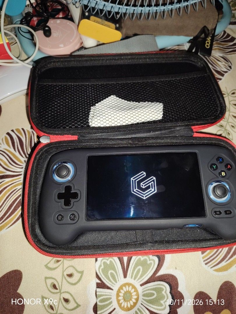 Anbernic RG556 (Category: Nintendo) located in Manila. Submitted by flashghie (Listing ID 1468164823, Image 2). Description: - Anbernic Android handheld gaming console in working condition - Custom UI setup with convenient home screen app shortcuts - Dual analog sticks, D-pad, and standard ABXY buttons - Includes fitted black protective silicone grip case - Comes with a zippered hard shell carry case featuring red trim and inner mesh pocket - Pow