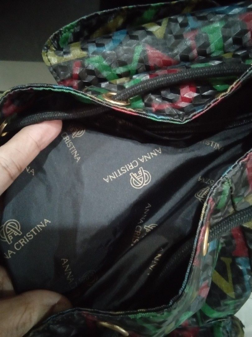 Anna Cristina Firenze Multi-Color Monogram Print Backpack (Category: Backpacks) located in Cabanatuan. Submitted by almaespino24263 (Listing ID 1468091774, Image 2). Description: - Brand: Anna Cristina Firenze - Design: Eye-catching multi-color letter print - Straps: Black fabric straps featuring woven brand logo - Interior: Branded lining with official cloth tag - Closure: Secure drawstring with a magnetic snap flap - Organization: Multiple zipp