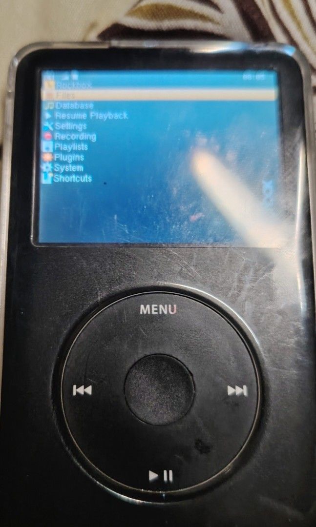Apple iPod Classic 6th Gen with RockBox OS and Case (Category: Portable Music Players) located in Manila. Submitted by flashghie (Listing ID 1468163717, Image 1). Description: - Classic Apple MP3 player running RockBox custom firmware - Monochrome click wheel layout with a color screen menu system - Back features a stylish silver carbon fiber texture skin - Includes a clear protective silicone case for drop and scratch defense - Fully tested, pow