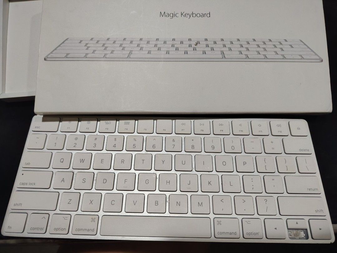 Apple Magic Keyboard with Touch ID (Category: Computer Keyboard) located in Mandaluyong City. Submitted by Love.Boutique (Listing ID 1468077910, Image 3). Description: - Authentic Apple Magic Keyboard with original box included - Clean white keys and sleek silver aluminum frame - Condition note: Down arrow keycap is loose or missing the top piece, but the switch underneath works perfectly - Ideal for use as a spare keyboard or an easy repair proj