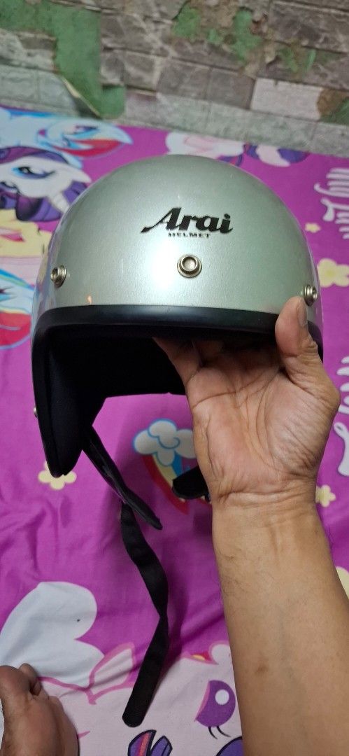 Arai Helmet Silver Open Face (Category: Caps & Hats) located in Quezon City. Submitted by robertlimbao (Listing ID 1468138134, Image 1). Description: - Brand: Arai - Type: Open face helmet - Color: Silver with black lining and chin strap - Features: Metal snap buttons along the top edge - Condition: Minor scratches and slight wear marks on the outer shell - Authentic and ready to use.
