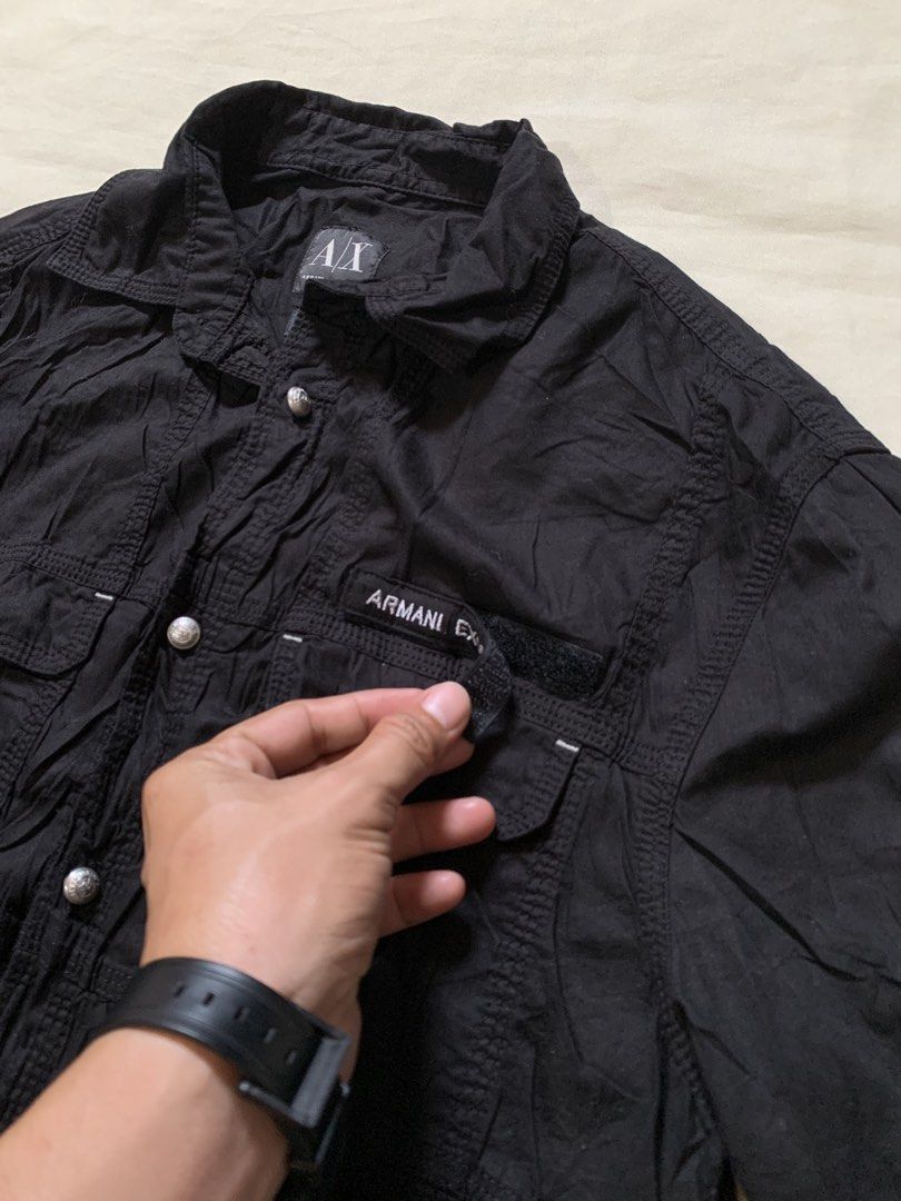 Armani Exchange Black Long Sleeve Button-Down Shirt (Category: Longsleeves) located in Davao. Submitted by cheineebau09680 (Listing ID 1468203072, Image 3). Description: - Brand: Armani Exchange - Color: Classic Black - Style: Long sleeve button-down shirt with textured fabric finish - Features: Dual front chest pockets with button closures - Detachable Armani Exchange logo patch on velcro - Premium branded silver-tone metal hardware on buttons a