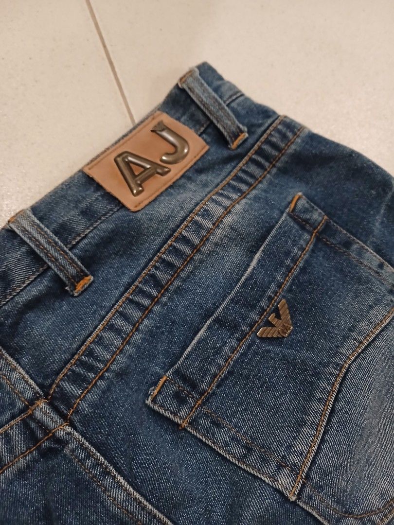 Armani Jeans Denim Pants (Category: Chinos) located in Daraga. Submitted by thethriftcity2024 (Listing ID 1468105586, Image 3). Description: - Brand: Armani Jeans (GA Operations S.p.A. Italy) - Color/Wash: Classic blue with clean wash and subtle thigh whiskering - Fit/Style: Straight leg, button fly, branded button closure - Material: 100% premium cotton - Details: Signature metal AJ badge on back pocket, contrast stitching, and inner yellow trim