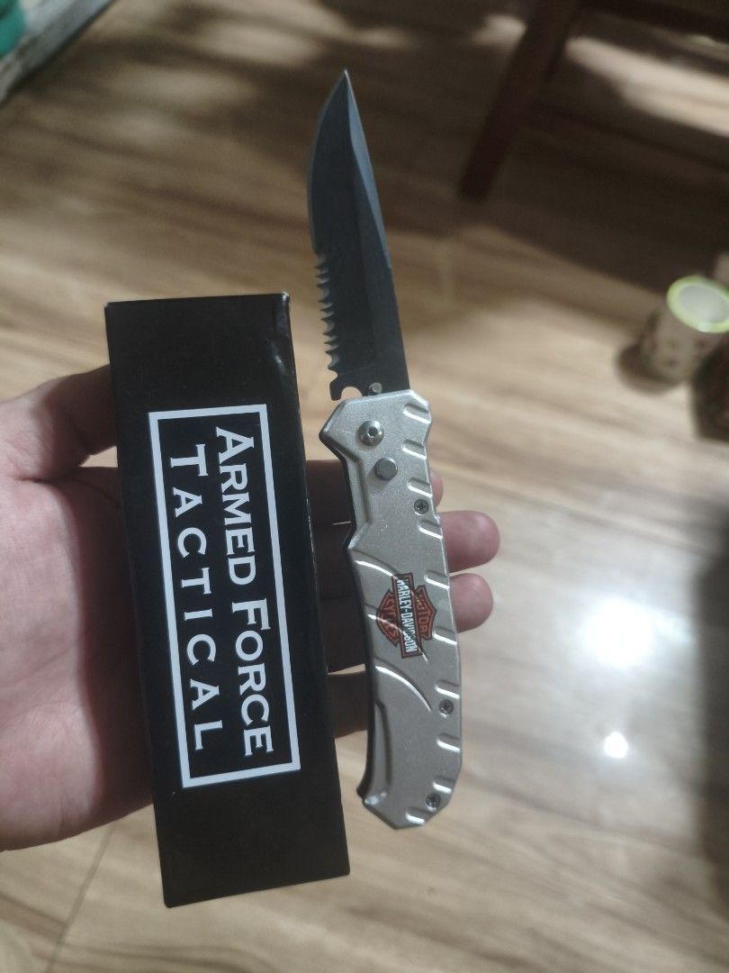 Armed Force Tactical Harley-Davidson 162HDSL Folding Knife (Category: Hiking & Camping) located in Baguio. Submitted by baguiobeans (Listing ID 1468184010, Image 1). Description: - Model: Armed Force Tactical 162HDSL with Harley-Davidson branding - Blade: Black 440C stainless steel, partially serrated - Handle: Silver finish with branded design - Features: Built-in back pocket clip for easy carry - Inclusion: Comes with the original black box - C