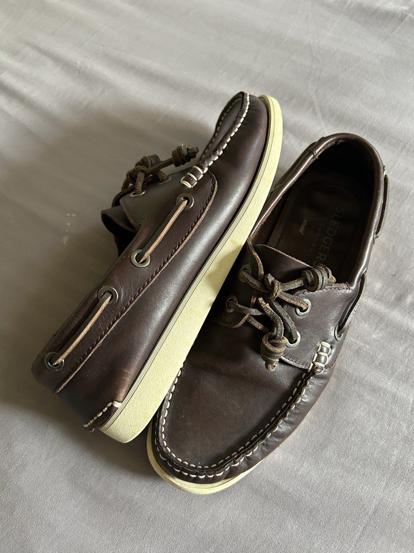 (Authentic) Sledgers McKenzie Leather Boat Shoes (Category: Casual Shoes) located in Carigara. Submitted by abiesclutter (Listing ID 1468088367, Image 2). Description: - Built with a smooth, dark brown leather upper that naturally develops character and a rich patina over time - Features iconic white contrast apron stitching along the moc-toe box - Employs a 360-degree rawhide leather lacing system thread - Set on a contrasting off-white rubber o