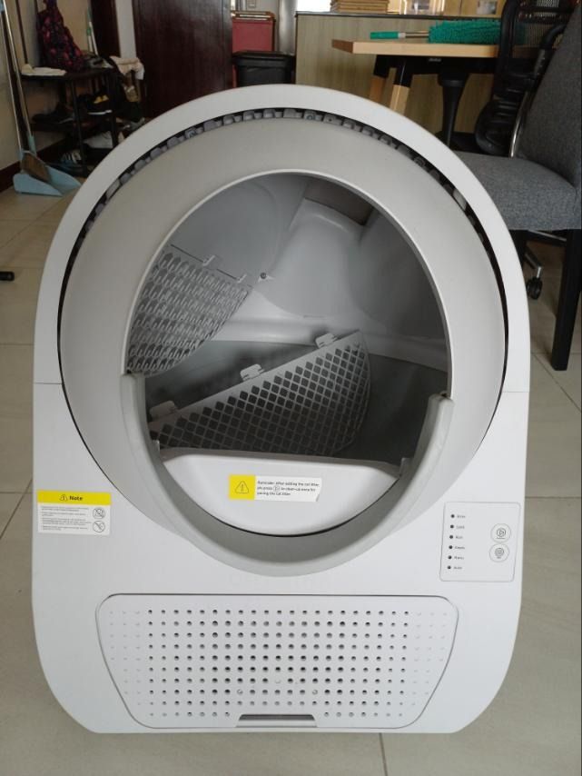 Automatic Self-Cleaning Cat Litter Box (Category: Health & Grooming) located in Caloocan City. Submitted by qualityseller02 (Listing ID 1468154226, Image 1). Description: - Automatic self-cleaning cat litter box - Modern white design with stylish grey trim - Open front entry with internal sifting grate and mesh screen - User-friendly control panel with status lights and operational buttons - Perforated waste bin compartment at the bottom front - 