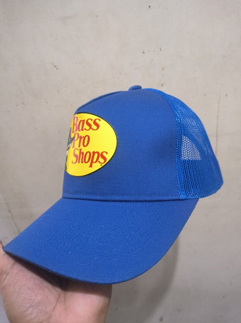 Bass Pro Shops Blue Trucker Hat (Category: Caps & Hats) located in Manila. Submitted by joshleyy (Listing ID 1468062801, Image 2). Description: - Color: Bright blue - Design: Structured front with iconic bass fish logo patch - Comfort: Breathable mesh back panels to keep you cool - Brim: Classic curved brim - Closure: Adjustable snapback for a custom fit - Condition: Clean and ready to wear.