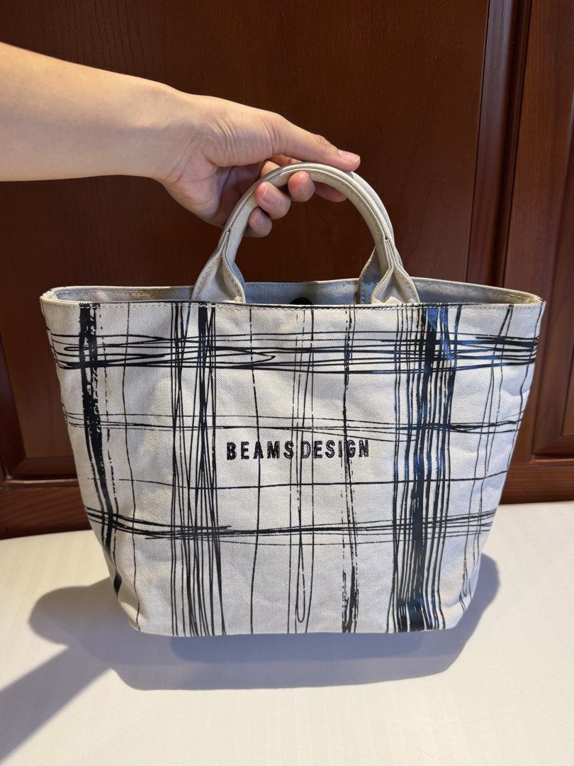 BEAMS DESIGN Screen Print Tote Bag Size S (Category: Tote Bags) located in Makati City. Submitted by keiiiiichan (Listing ID 1468067770, Image 2). Description: - Authentic BEAMS DESIGN canvas tote bag in a stylish black scribble plaid pattern - Dimensions: 36cm (W) x 23cm (H) x 14cm (D) with an 8cm handle drop - Secure magnetic snap button top closure - Structured flat base that stands upright easily - Black interior lining featuring one zippered