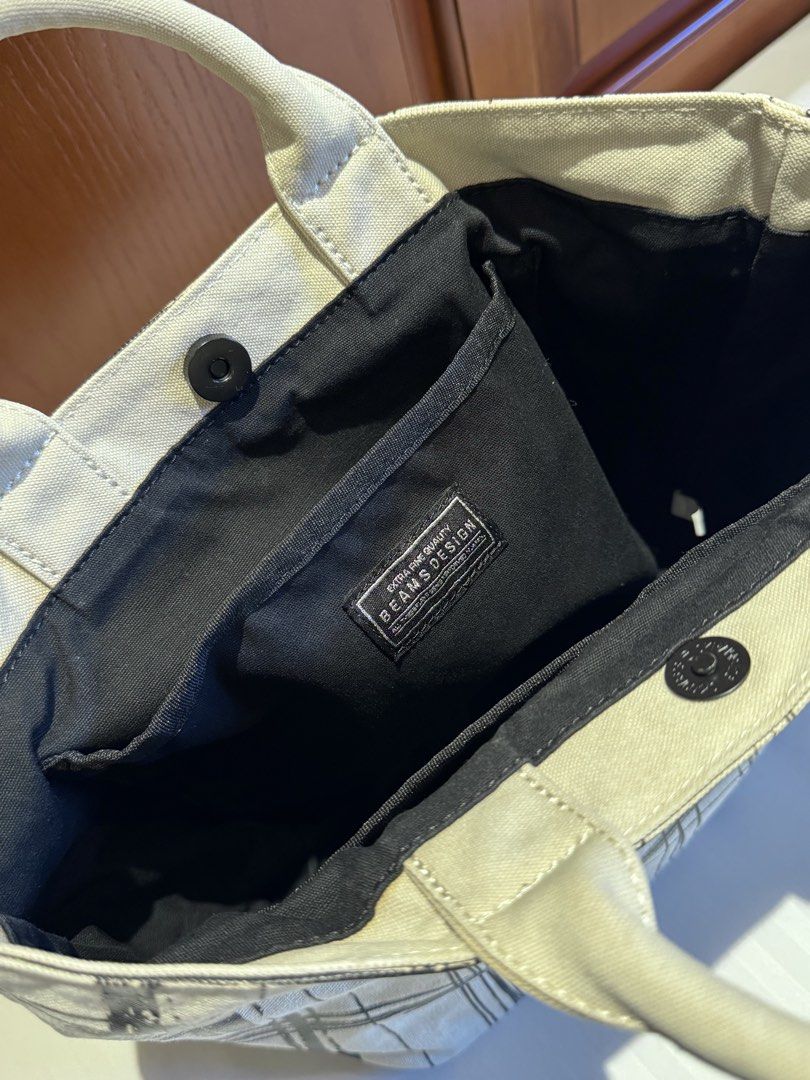 BEAMS DESIGN Screen Print Tote Bag Size S (Category: Tote Bags) located in Makati City. Submitted by keiiiiichan (Listing ID 1468067770, Image 3). Description: - Authentic BEAMS DESIGN canvas tote bag in a stylish black scribble plaid pattern - Dimensions: 36cm (W) x 23cm (H) x 14cm (D) with an 8cm handle drop - Secure magnetic snap button top closure - Structured flat base that stands upright easily - Black interior lining featuring one zippered