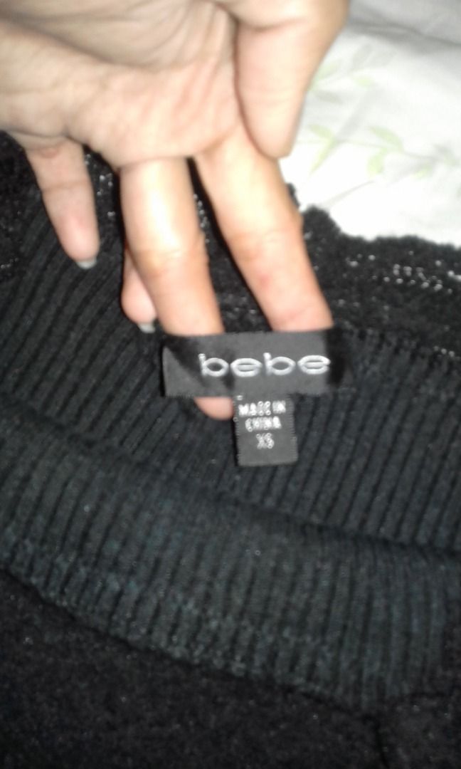 Bebe Black Ribbed Knit Sweater Size XS (Category: Longsleeves) located in La Trinidad. Submitted by roseee.a84fe6 (Listing ID 1468212271, Image 3). Description: - Brand: Bebe - Size: XS - Color: Black - Material: Warm textured ribbed knit - Features: Classic crew neckline with thick ribbed collar trim - Origin: Made in China - Condition: Clean label inside, great basic piece for layering.