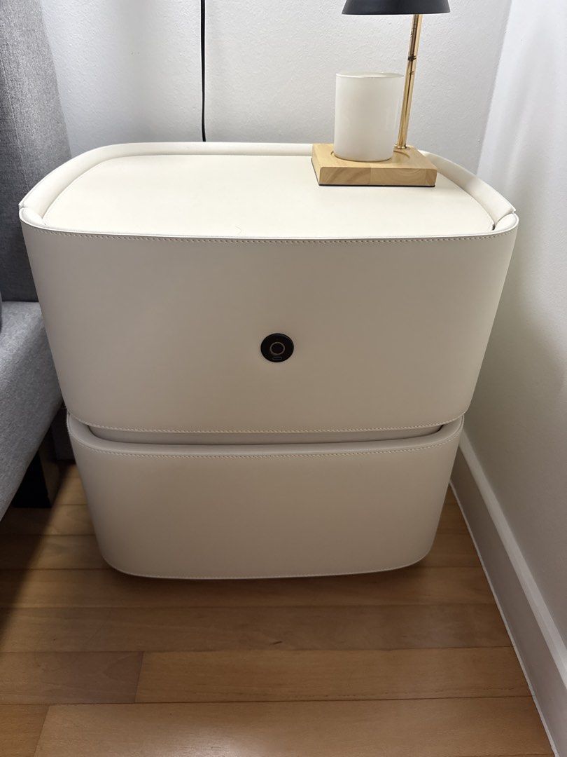 Bedside table (Category: Tables & Sets) located in Singapore. Submitted by redcrumble (Listing ID 1468062315, Image 1). Description: Off white colour Top compartment comes with non functional fingerprint lock Soft closure drawers Leather interior and exterior 50x40x50cm .