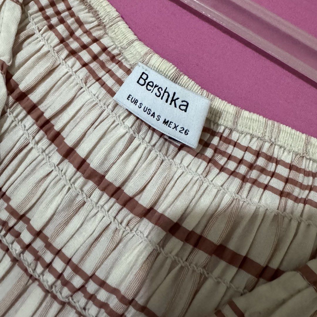 Bershka Plaid Smocked Top (Category: Blouses) located in San Fernando. Submitted by declotter (Listing ID 1468081569, Image 3). Description: - Brand: Bershka - Color: White with brown plaid stripes - Design: V-neckline with ruffled cap sleeves and peplum hem - Fit: Stretchy body for a comfortable fit - Style: Versatile, easy to dress up with jeans or a skirt .