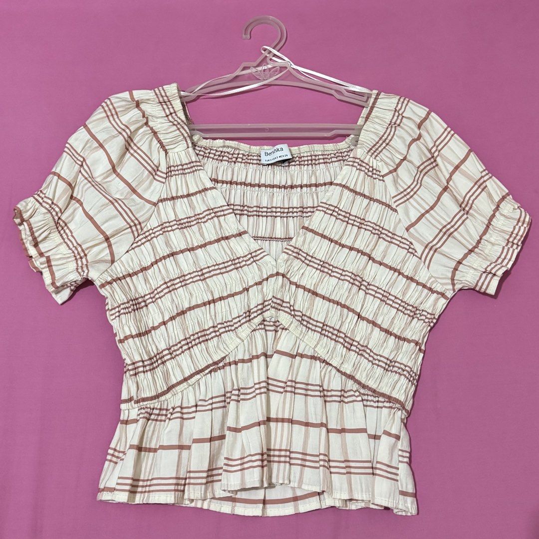 Bershka Plaid Smocked Top (Category: Blouses) located in San Fernando. Submitted by declotter (Listing ID 1468081569, Image 1). Description: - Brand: Bershka - Color: White with brown plaid stripes - Design: V-neckline with ruffled cap sleeves and peplum hem - Fit: Stretchy body for a comfortable fit - Style: Versatile, easy to dress up with jeans or a skirt .