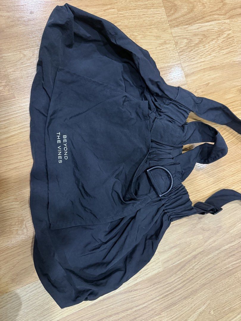 Beyond The Vines Black Dumpling Bag in Medium (Category: Shoulder Bags) located in Manila. Submitted by shopishka (Listing ID 1468219278, Image 3). Description: Beyond The Vines black shoulder bag. Lightweight nylon material, gathered elasticized opening. Front pocket with printed white logo lettering. Adjustable crossbody strap attached, plus dual top carry handles. Handy D-ring hardware on the front. Clean interior, gently carried a few times. 