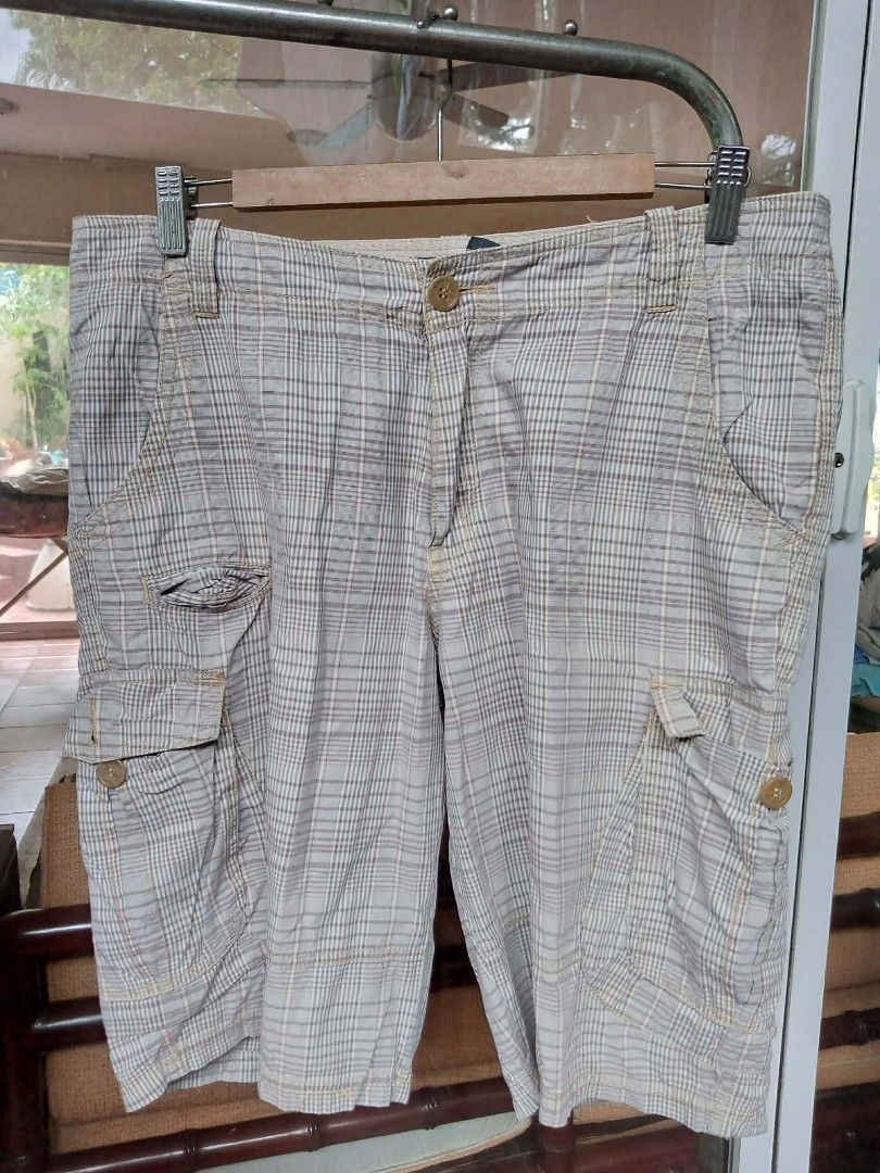 cargo shorts BILLABONG Limited Edition (Category: Shorts) located in Pasig City. Submitted by rjkfindsofficial (Listing ID 1468133074, Image 2). Description: - Brand: Billabong - Style: Grey plaid cargo shorts / Skater style - Size: 32 waist - Features: Multiple pockets with button flaps on sides and back - Condition: Good for daily wear with minor visible staining on the back and lower leg area.