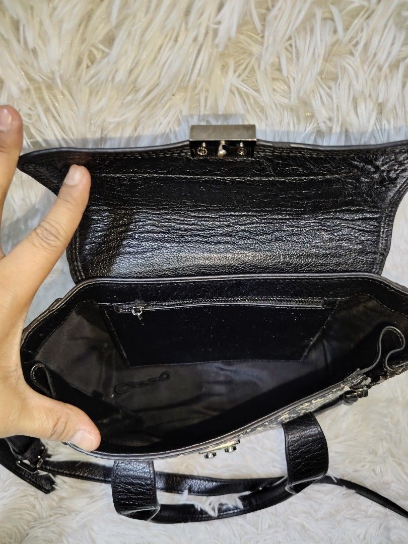 Black and patterned leather satchel handbag (Category: Cross-body Bags) located in Quezon City. Submitted by zhelcloset01 (Listing ID 1468068940, Image 3). Description: - Material: Premium black leather with a stylish textured black and white front panel - Closure: Secure metal push-lock on the flap - Versatile Carry: Includes dual top handles and a detachable, adjustable shoulder strap - Interior: Dark patterned fabric lining featuring a zip poc