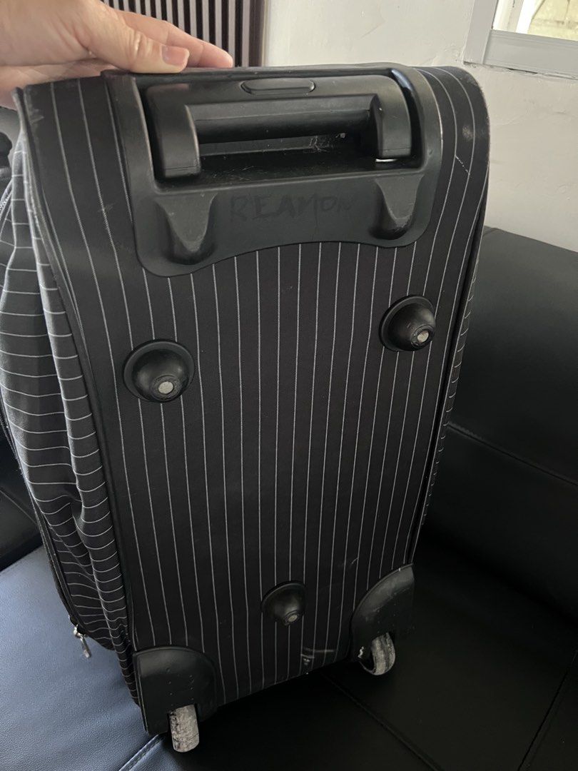 Black and white striped rolling duffel bag with handle (Category: Tote Bags) located in Manila. Submitted by nuttshellw52293 (Listing ID 1468107402, Image 1). Description: - Color & Pattern: Black with all-over white pinstripes - Mobility: Extendable metal pull handle and smooth-rolling inline wheels - Carry Options: Double grab handles and a long detachable shoulder strap - Storage: Multiple zippered compartments and a handy front pocket - Stabi
