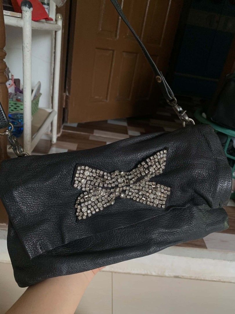 Black leather shoulder bag with rhinestone bow (Category: Shoulder Bags) located in Tiaong. Submitted by cdoswan (Listing ID 1468204364, Image 2). Description: - Color: Classic black - Material: Soft textured leather - Design: Slouchy shape with a dazzling rhinestone bow on the front flap - Strap: Sleek thin black shoulder strap - Closure: Convenient snap closure - Versatility: Great size for daily use or evening events - Condition: Brand new / E