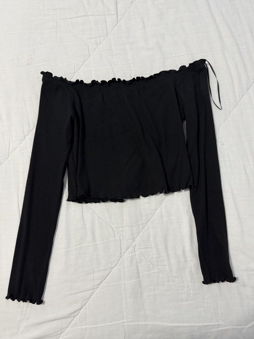Black ribbed off-shoulder long sleeve crop top (Category: Longsleeves) located in Manila. Submitted by zxcvbnmsof (Listing ID 1468211755, Image 1). Description: - Color: Classic Black - Style: Off-shoulder long sleeve top with cute ruffled neckline, cuffs, and hem - Material: Stretchy, comfortable ribbed knit fabric - Condition: Excellent, no stains or loose threads - Versatility: Great for layering or wearing on its own.