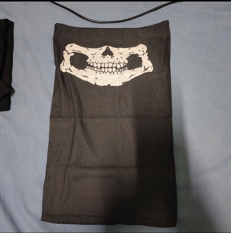 Black Skull Neck Gaiter Face Mask (Category: Scarves) located in Quezon City. Submitted by dncpreloved (Listing ID 1468158036, Image 1). Description: - Color: Black with white skull jaw and teeth print - Material: Stretchy, comfortable fabric - Design: Seamless tubular style with easy pull-on wear - Versatile: Can be worn as a face mask, headband, or neck warmer - Ideal for: Motorcycling, cycling, hiking, and other outdoor adventures.