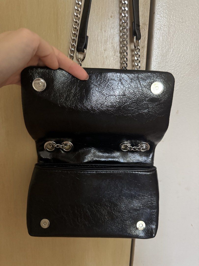 Black Studded Shoulder Bag with Chain Strap (Category: Cross-body Bags) located in Muntinlupa City. Submitted by francesca14 (Listing ID 1468077021, Image 2). Description: - Style: Black crinkled patent finish shoulder bag with silver-tone front studs - Closure: Secure magnetic snap closure - Strap: Double chain and faux leather strap - Interior: Multiple compartments with a slip pocket and clean lining with tag attached - Versatility: Great size