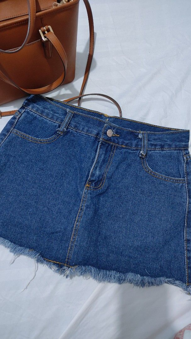 Blue denim skort with raw frayed hem (Category: Skirts) located in Bacolor. Submitted by annjjjjj (Listing ID 1468080283, Image 1). Description: - Color/Wash: Medium wash blue denim - Closure: Front button closure with belt loops - Details: Classic yellow contrast stitching and trendy raw frayed hem - Fit: Standard waist size - Style: Versatile basic piece, perfect for casual everyday wear.