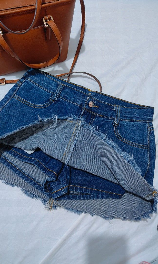 Blue denim skort with raw frayed hem (Category: Skirts) located in Bacolor. Submitted by annjjjjj (Listing ID 1468080283, Image 2). Description: - Color/Wash: Medium wash blue denim - Closure: Front button closure with belt loops - Details: Classic yellow contrast stitching and trendy raw frayed hem - Fit: Standard waist size - Style: Versatile basic piece, perfect for casual everyday wear.