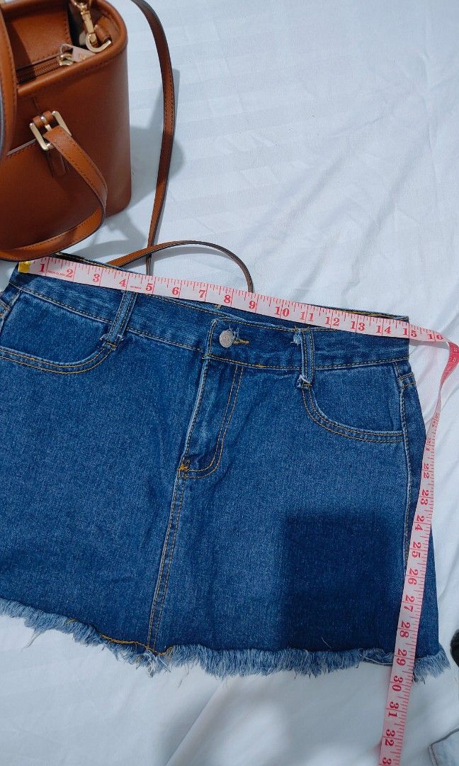 Blue denim skort with raw frayed hem (Category: Skirts) located in Bacolor. Submitted by annjjjjj (Listing ID 1468080283, Image 3). Description: - Color/Wash: Medium wash blue denim - Closure: Front button closure with belt loops - Details: Classic yellow contrast stitching and trendy raw frayed hem - Fit: Standard waist size - Style: Versatile basic piece, perfect for casual everyday wear.
