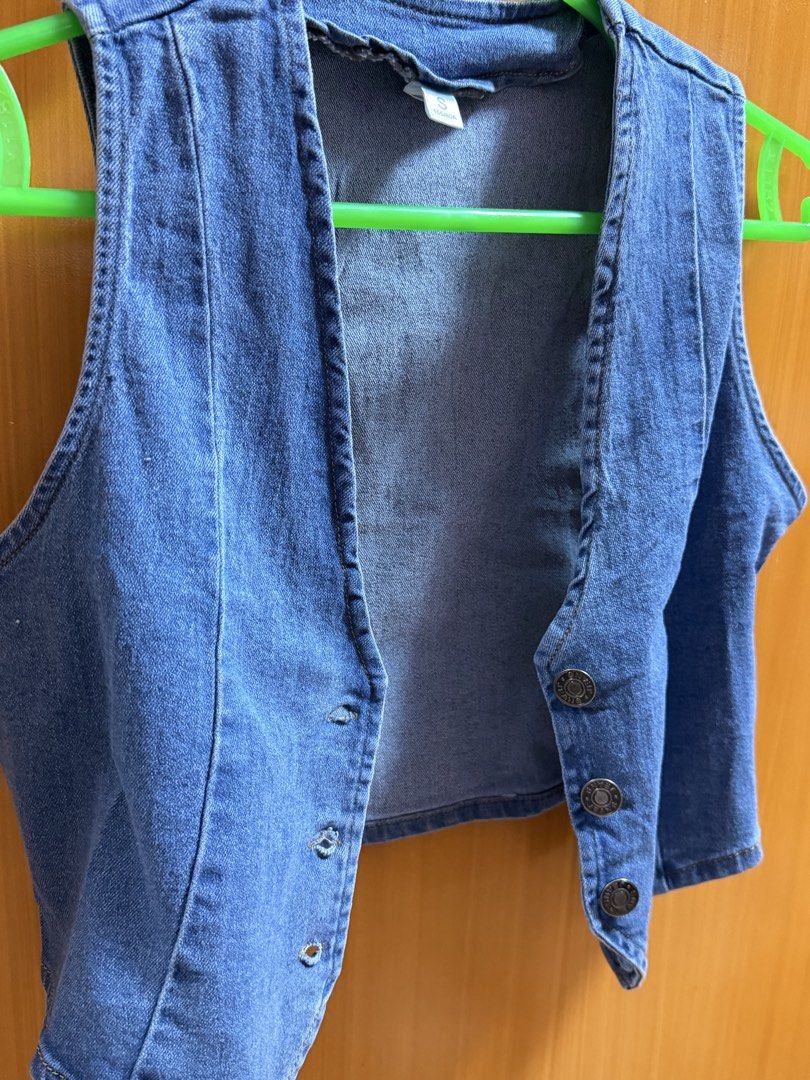 Blue denim vest crop top button up size S (Category: Sleeveless) located in Bacoor. Submitted by happyfish_028a6c (Listing ID 1468066633, Image 1). Description: Blue denim vest with a V-neck and metal buttons down the front. Cropped fit with panel stitching. Size S tag on the collar, measuring 155/80A. Material feels sturdy and classic denim blue. Great layering piece..