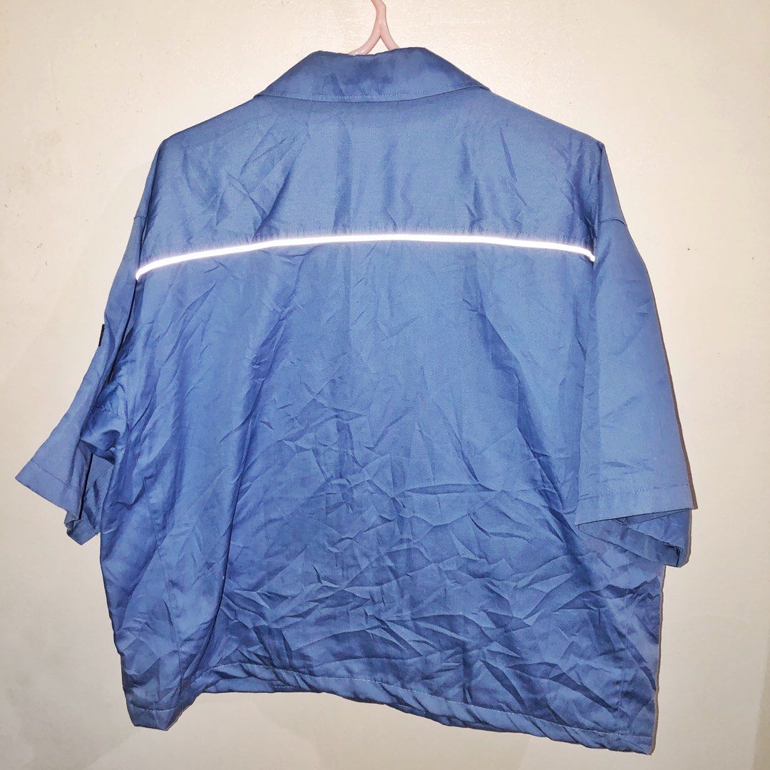 Blue Reflective Workwear Cropped Polo 💙 (Category: Tshirts & Polo Shirts ) located in Antipolo. Submitted by minitaco (Listing ID 1468069178, Image 2). Description: Selling this blue short-sleeve workwear polo featuring reflective strips across the chest. Designed with a collared neckline, zipper closure, two buttoned chest pockets, and a practical utility-style design. Lightweight-fabric with a relaxed fit, making it suitable for workwear, outd