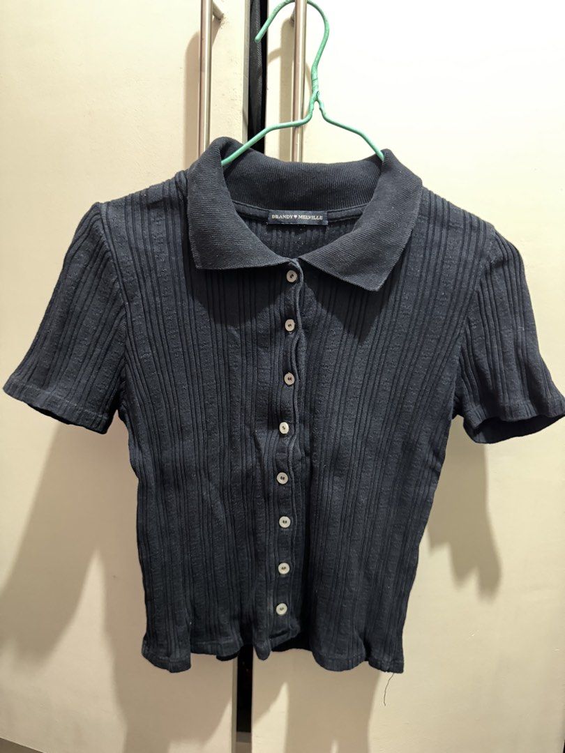 Brandy Melville Black Ribbed Polo Top (Category: Shirts) located in Rosales. Submitted by thriftingismygame (Listing ID 1468170270, Image 1). Description: - Brand: Brandy Melville - Color: Black - Style: Short sleeve ribbed polo shirt with button-up front and classic collar - Fit: Fitted cut - Versatile basic piece, easy to style with jeans or skirts.