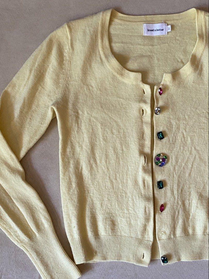 Bread n Butter Yellow Rhinestone Button Cardigan (Category: Longsleeves) located in Quezon City. Submitted by rosealison (Listing ID 1468129387, Image 2). Description: - Brand: bread n butter - Fits Extra Small or Small - Color: Butter yellow pastel - Material: Knit fabric with ribbed hem and cuffs - Details: Scoop neckline, long sleeves, and fun multicolored jewel/gemstone front buttons - Style: Great for layering.