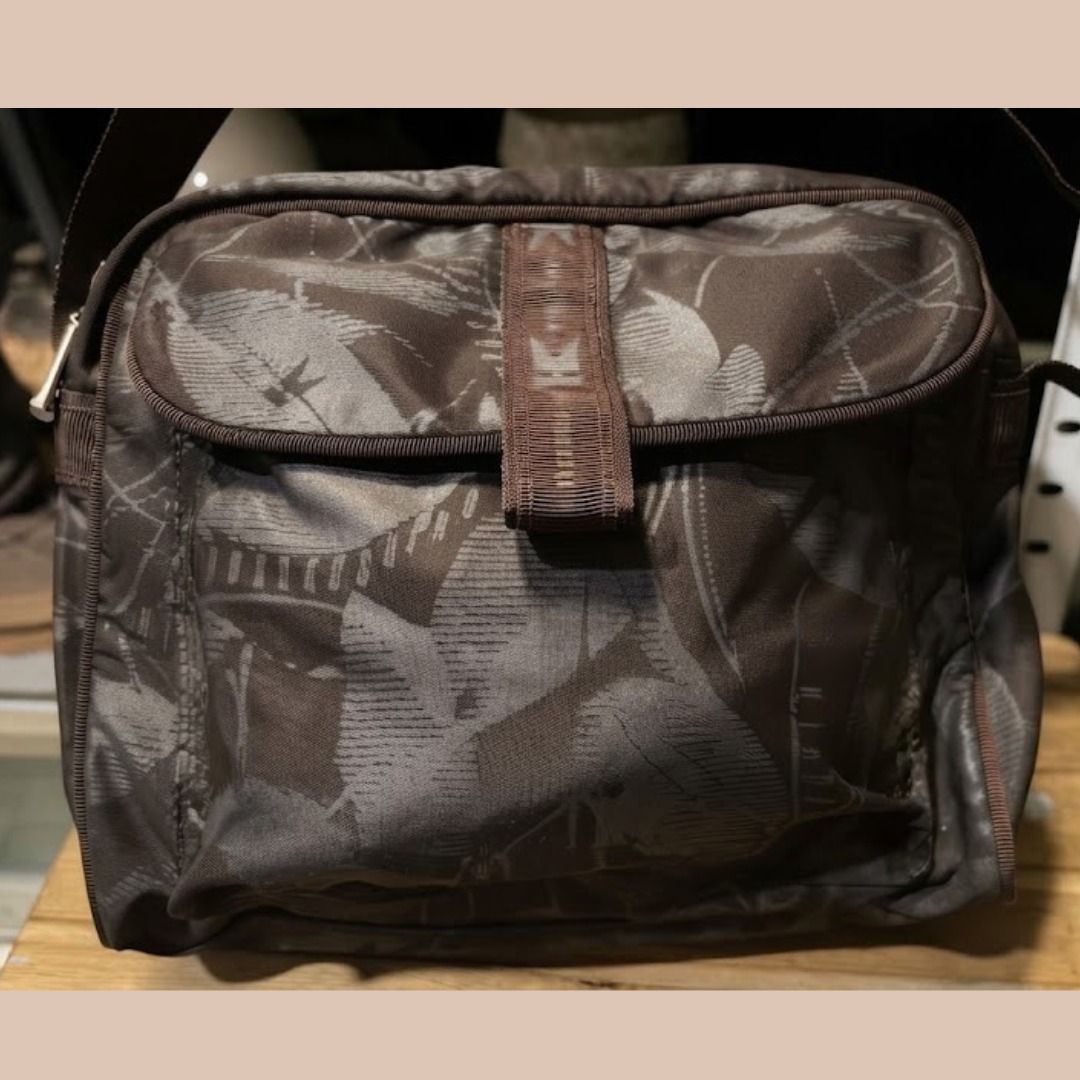 Brown leaf pattern messenger shoulder bag (Category: Shoulder Bags) located in Quezon City. Submitted by eilgaraje (Listing ID 1468207371, Image 3). Description: - Stylish brown shoulder bag with an all-over leaf pattern - Versatile neutral earth tones to match any outfit - Adjustable strap for comfortable crossbody or shoulder wear - Front flap closure with a trendy center webbing detail and buckle-style snap - Spacious interior with plenty of r