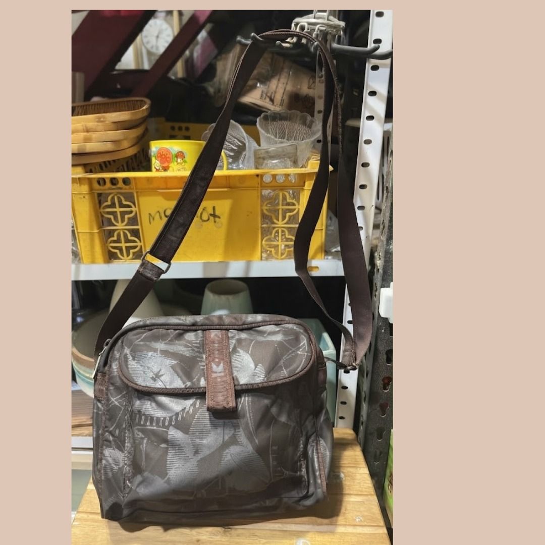 Brown leaf pattern messenger shoulder bag (Category: Shoulder Bags) located in Quezon City. Submitted by eilgaraje (Listing ID 1468207371, Image 2). Description: - Stylish brown shoulder bag with an all-over leaf pattern - Versatile neutral earth tones to match any outfit - Adjustable strap for comfortable crossbody or shoulder wear - Front flap closure with a trendy center webbing detail and buckle-style snap - Spacious interior with plenty of r