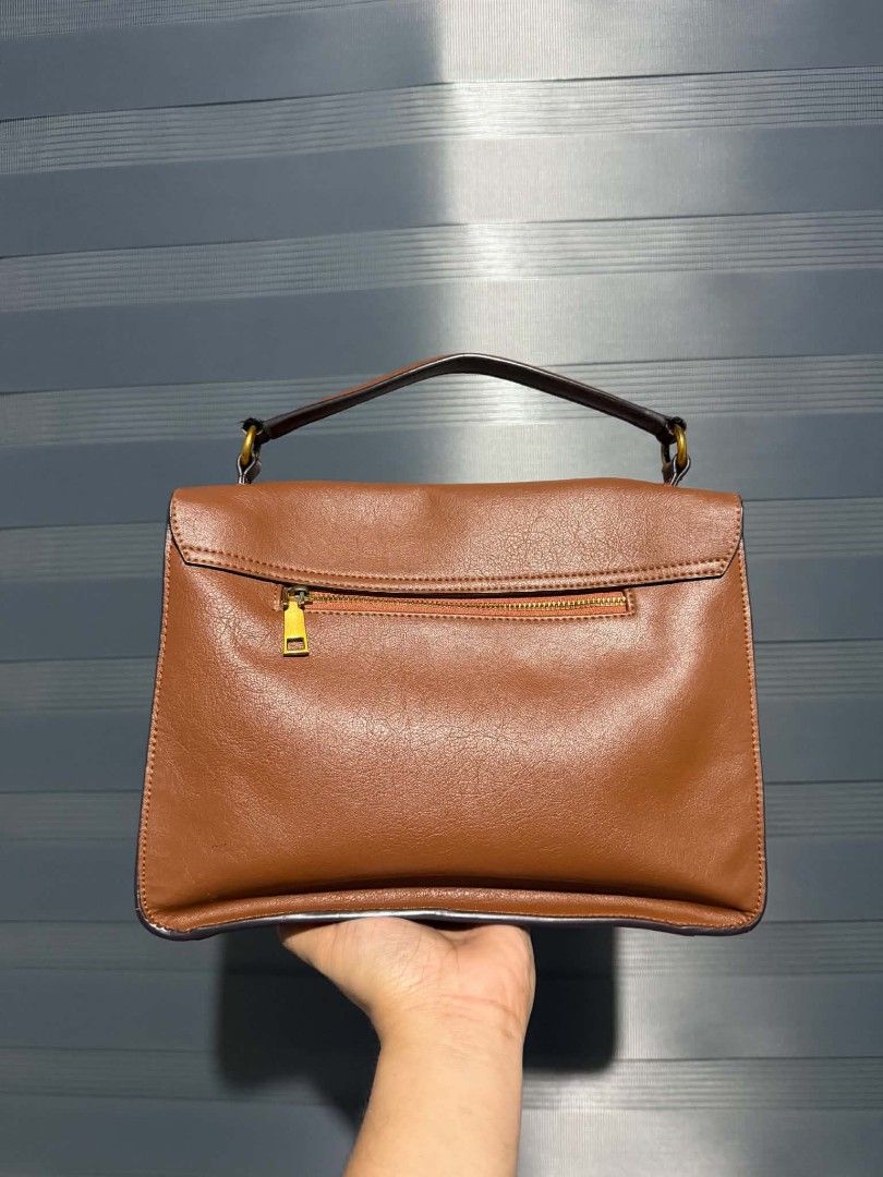Brown Leather Handbag Satchel With Detachable Strap (Category: Luxury Bags & Wallets) located in Manila. Submitted by peptaura (Listing ID 1468281599, Image 3). Description: - Color: Tan brown - Design: Structured body bag with envelope front flap - Closure: Secure gold-tone twist lock - Storage: Convenient exterior back zipper pocket - Straps: Includes a matching adjustable shoulder strap with lobster clasps - Handle: Solid top handle with sturd