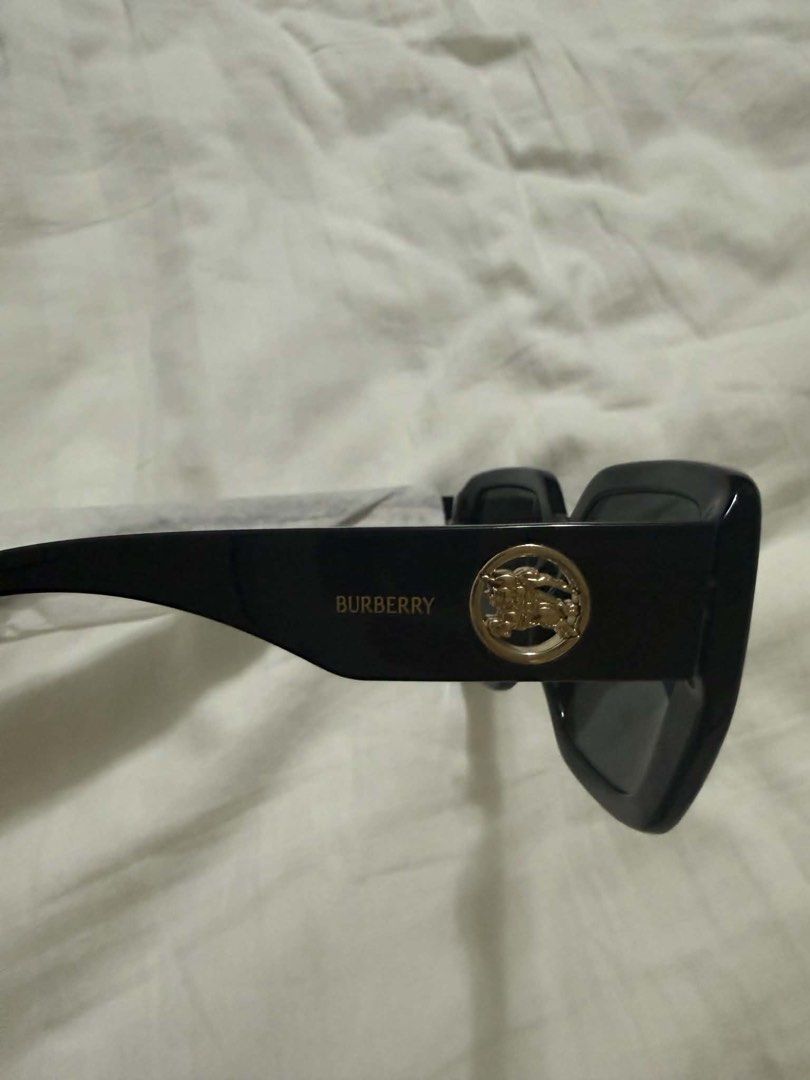 Burberry Black Square Sunglasses with Gold Logo (Category: Sunglasses & Eyewear) located in Makati City. Submitted by abbygi168 (Listing ID 1468072821, Image 2). Description: - Brand: Burberry - Style: Black square frames with dark tinted lenses - Details: Gold lettering and circular horse crest on the arm - Condition: Brand new, never worn, pristine condition - Inclusions: Original white box, case, and paperwork included.