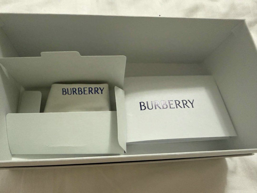 Burberry Black Square Sunglasses with Gold Logo (Category: Sunglasses & Eyewear) located in Makati City. Submitted by abbygi168 (Listing ID 1468072821, Image 3). Description: - Brand: Burberry - Style: Black square frames with dark tinted lenses - Details: Gold lettering and circular horse crest on the arm - Condition: Brand new, never worn, pristine condition - Inclusions: Original white box, case, and paperwork included.