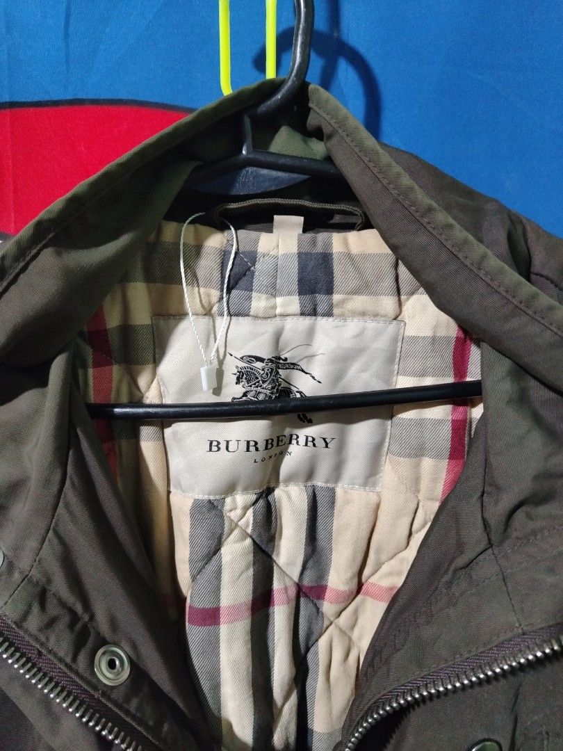 Burberry London Brown Quilted Check Jacket (Category: Coats, Jackets and Outerwear) located in Lucena. Submitted by thrifteditem (Listing ID 1468236973, Image 3). Description: Burberry London brown utility jacket with iconic check lining inside. Multiple front pockets, snap buttons, zip closure with YKK hardware. Stand collar with buckle strap detail. Classic winter outerwear piece in earthy tones..