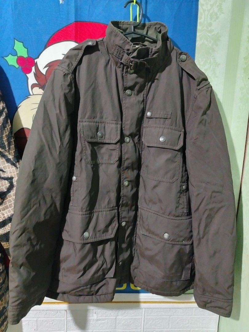 Burberry London Brown Quilted Check Jacket (Category: Coats, Jackets and Outerwear) located in Lucena. Submitted by thrifteditem (Listing ID 1468236973, Image 1). Description: Burberry London brown utility jacket with iconic check lining inside. Multiple front pockets, snap buttons, zip closure with YKK hardware. Stand collar with buckle strap detail. Classic winter outerwear piece in earthy tones..