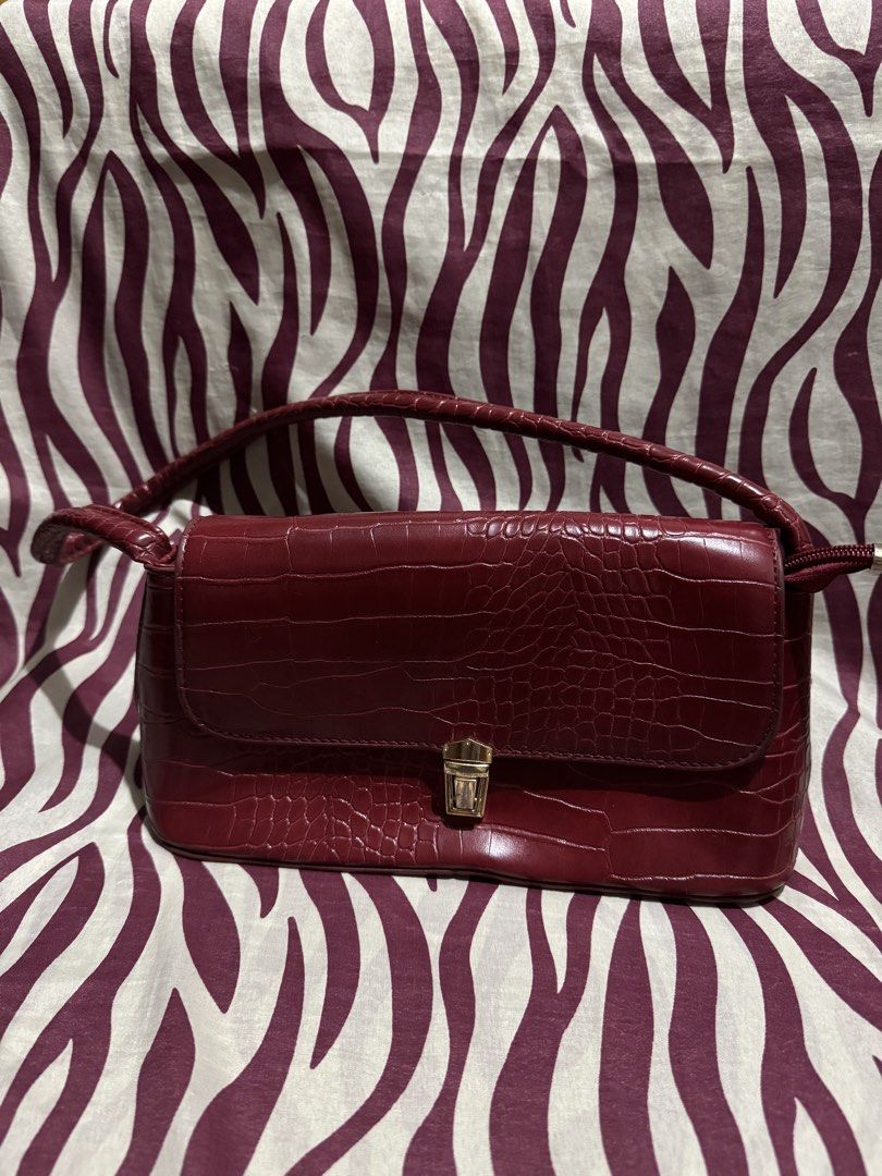 Burgundy Crocodile Pattern Shoulder Bag (Category: Shoulder Bags) located in Taguig. Submitted by justlikenewthriftshop.ph (Listing ID 1468131255, Image 1). Description: Gorgeous burgundy faux leather shoulder bag with a chic croc texture and gold-tone hardware. Features a secure turn-lock flap, top handle, and a clean interior with a handy zip pocket. Perfect for adding a touch of elegance to any outfit. Bossing/Momshie approved, grab it before 