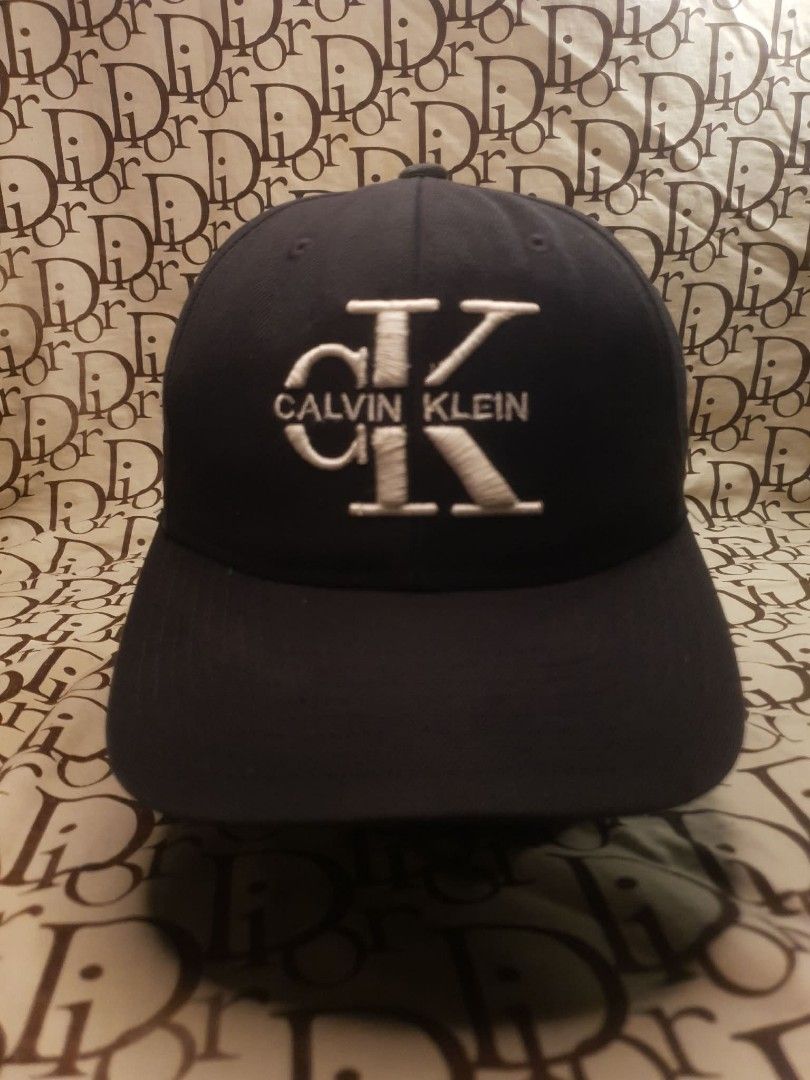 CALVIN KLEIN BLACK SNAPBACK CAP (Category: Caps & Hats) located in San Fernando. Submitted by _jaximus (Listing ID 1468217160, Image 1). Description: - Brand: Calvin Klein - Color: Classic black with white embroidered CK logo - Closure: Adjustable snapback for a custom fit - Design: Structured crown and curved brim - Style: Versatile and clean, perfect for any casual look - Size: Standard adult sizing.