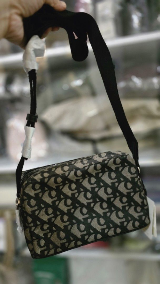 Calvin Klein Monogram Crossbody Bag (Category: Cross-body Bags) located in Quezon City. Submitted by momof3_11 (Listing ID 1468231993, Image 1). Description: - Brand: Calvin Klein - Condition: Brand new with tags attached - Design: Dark monogram print pattern with black leather bottom base for structure - Closure & Hardware: Secure double zip closure with sleek silver hardware - Strap: Adjustable black shoulder strap (still wrapped in protective 