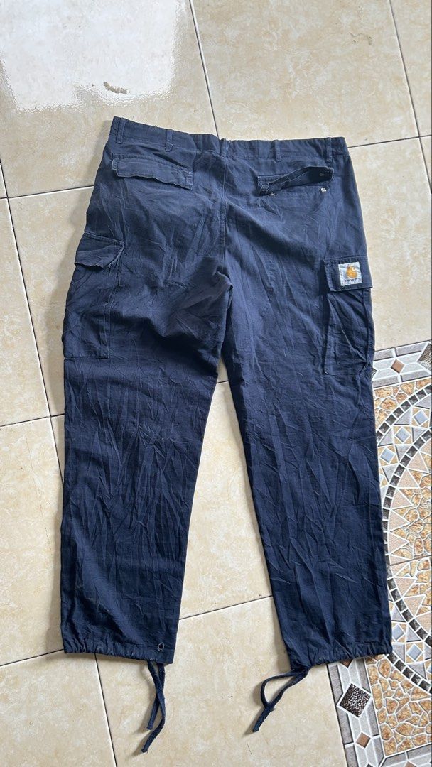 Carhartt Cargo Pants (33-36) (Category: Jeans) located in General Santos City (Dadiangas). Submitted by moana_thrifts (Listing ID 1468092072, Image 2). Description: - Brand: Carhartt WIP - Color: Navy Blue - Material: 100% Cotton (Made in Tunisia) - Features: Multiple utility pockets on legs and back - Details: Branded metal button closure & iconic woven square label on back pocket - Fit: Adjustable drawstring cuffs at the ankles - Condition: Exc