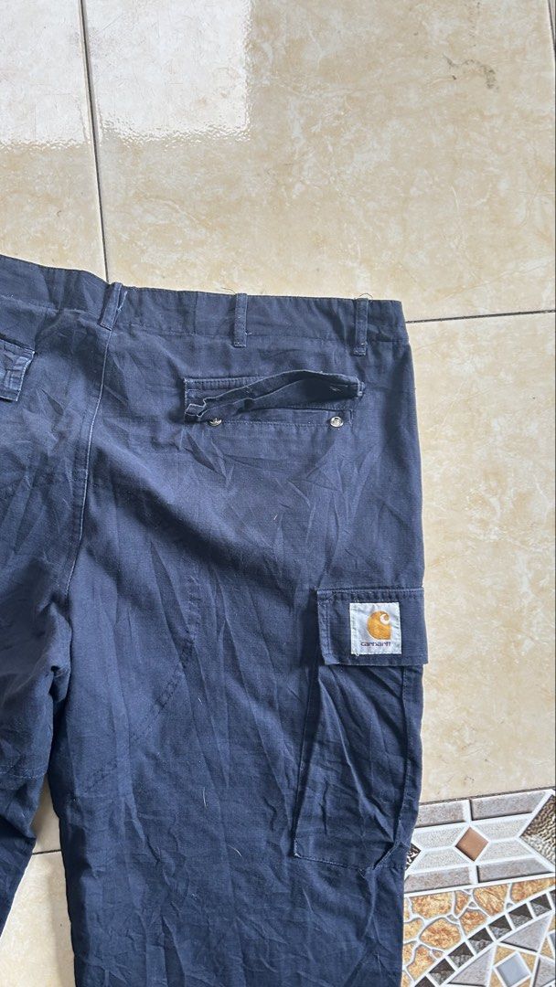 Carhartt Cargo Pants (33-36) (Category: Jeans) located in General Santos City (Dadiangas). Submitted by moana_thrifts (Listing ID 1468092072, Image 3). Description: - Brand: Carhartt WIP - Color: Navy Blue - Material: 100% Cotton (Made in Tunisia) - Features: Multiple utility pockets on legs and back - Details: Branded metal button closure & iconic woven square label on back pocket - Fit: Adjustable drawstring cuffs at the ankles - Condition: Exc
