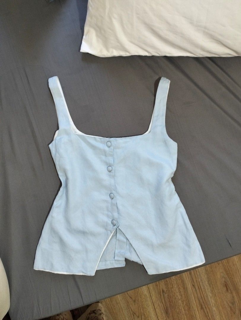 Cariño light blue button-front tank top size XS (Category: Sleeveless) located in Manila. Submitted by jasja (Listing ID 1468085267, Image 1). Description: - Brand: Cariño - No WW - Size: XS - Color: Light blue - Design: Sleeveless with square neckline and matching front buttons - Lining: White interior lining - Condition: Good overall, with some yellowing visible on the inside collar and strap lining - Origin: Made in the Philippines.