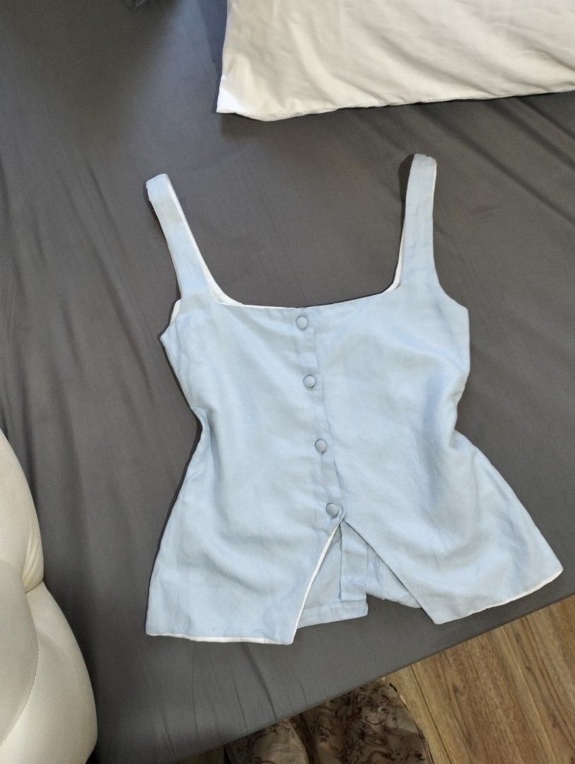 Cariño light blue button-front tank top size XS (Category: Sleeveless) located in Manila. Submitted by jasja (Listing ID 1468085267, Image 3). Description: - Brand: Cariño - No WW - Size: XS - Color: Light blue - Design: Sleeveless with square neckline and matching front buttons - Lining: White interior lining - Condition: Good overall, with some yellowing visible on the inside collar and strap lining - Origin: Made in the Philippines.