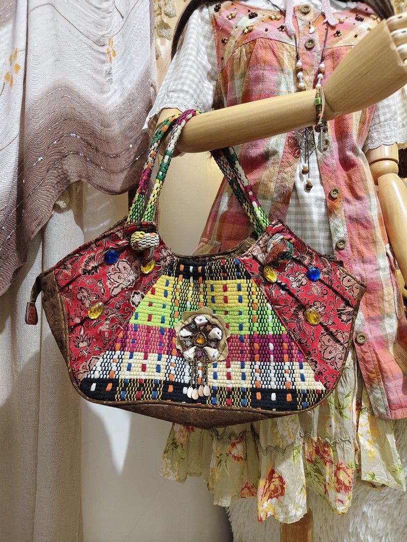 CD:B02 Fairy Boho shoulder bag (Category: Shoulder Bags) located in Manila. Submitted by chynii_28 (Listing ID 1468132089, Image 2). Description: - Style: Fairy boho shoulder bag with colorful woven and patterned fabric - Accents: Embellished with colorful gems, beads, and a central shell - Straps: Twin shoulder straps in green and patterned fabric (17" strap length) - Dimensions: 10" length/height x 17.5" width - Condition: Clean interior and ex
